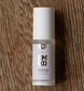A bottle of EMKO KO Peptide Dual System Day Night Serum win an air pump dispenser white cap, resting on a brown wood grain background. It has advanced peptides for day and night use. 